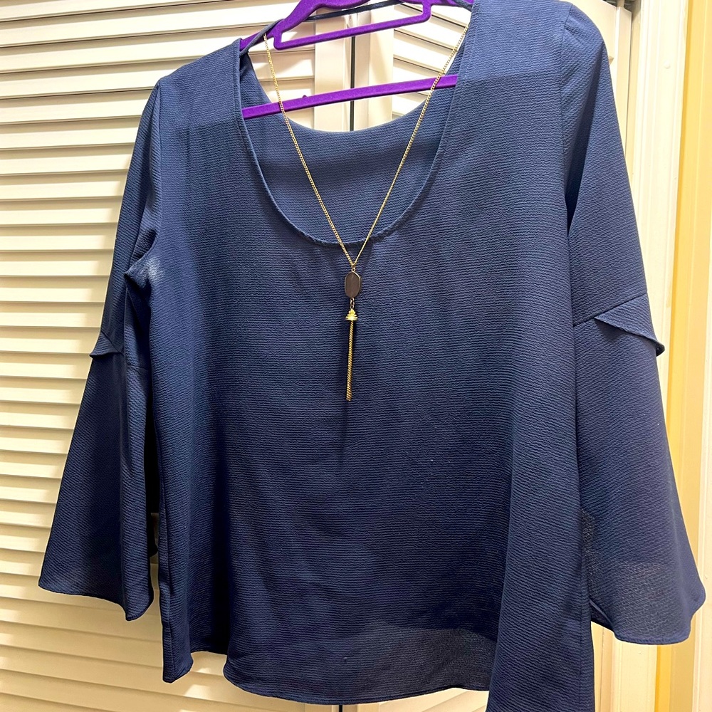 Navy blue blouse with long gold necklace attached. Very flattering.
